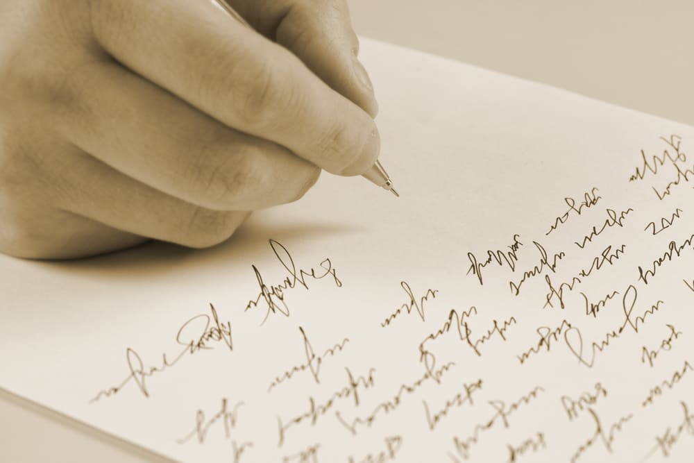 A photo of a hand writing a letter